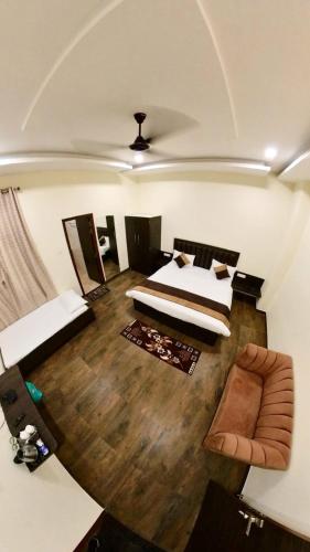 a large room with two beds and a couch at Hotel Govindam Elite in Juhi Bari