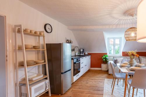 a kitchen with a stainless steel refrigerator and a table at Moderne Ferienwohnung mit Festungsblick im Zentrum in Königstein an der Elbe