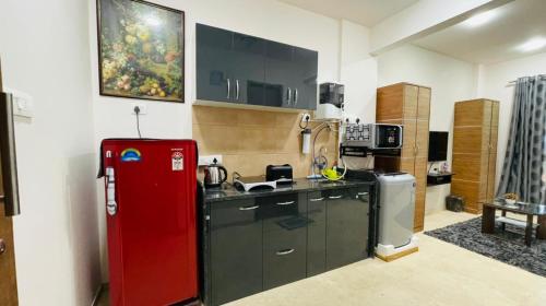 a kitchen with a red refrigerator in a room at NASHVILLE - Apartment with Modern Amenities in Igatpuri