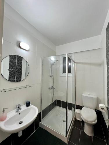 a bathroom with a shower and a toilet and a sink at Fat Cow Apartments in Larnaka