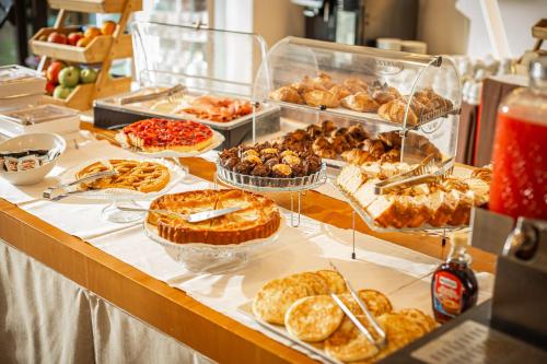 a buffet filled with different types of pastries and pies at NEW IPOINT HOTEL in San Giovanni in Persiceto