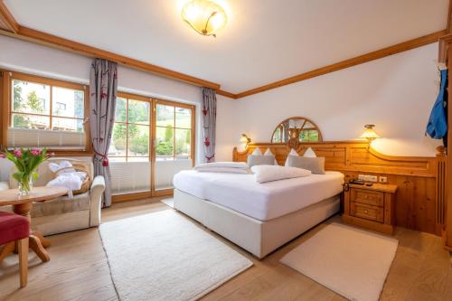 a bedroom with two beds and a desk and a table at Vitalhotel Sonnenhof in Going