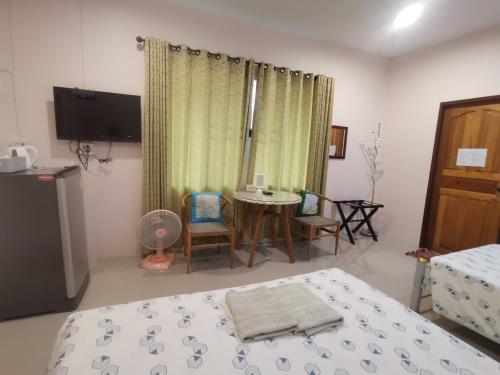 a bedroom with a bed and a table and chairs at Numhom Resort in Ban Nong Chum Saeng