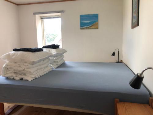 uma cama num quarto com duas pilhas de lençóis em Upstairs em Sæby