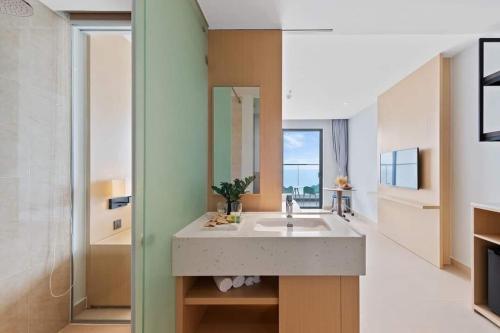La salle de bains est pourvue d'un lavabo et d'un miroir. dans l'établissement Sea view at The Arena Cam Ranh resort, Bai Dai beach, near airport Nha Trang, Khanh Hoa, à Thôn Hòa Ða