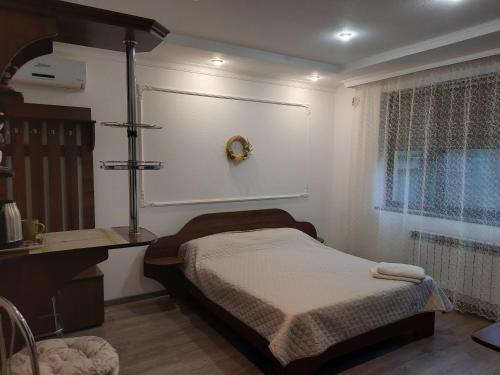 1 dormitorio con cama, escritorio y ventana en Комфортный en Karpaty