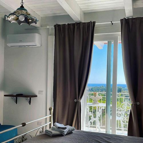 a bedroom with a bed and a large window at L'incanto di Nausicaa in Ascea