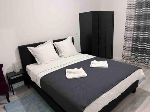 a bedroom with a large bed with two towels on it at Appartement proche Paris, C DG, Disney, Parking. in Aulnay-sous-Bois