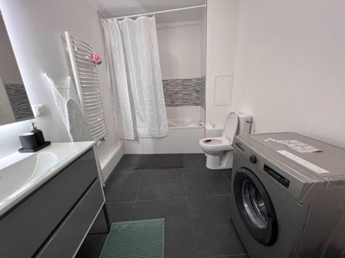 a white bathroom with a washing machine in it at Appartement proche Paris, C DG, Disney, Parking. in Aulnay-sous-Bois