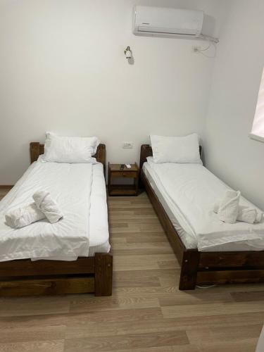 two twin beds in a room with a fan at Casa Marko in Nădlac