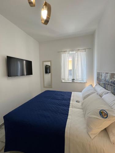 a bedroom with a blue and white bed and a tv at B&B Centro Storico in Diamante