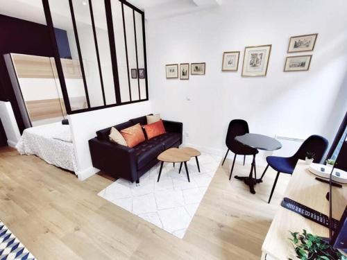 a living room with a couch and a table and chairs at Studio standing plein centre Aix in Aix-en-Provence