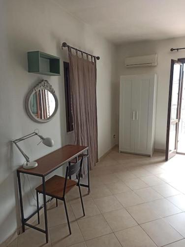a desk with a lamp and a chair in a room at A terrace in the heart of Palermo in Palermo