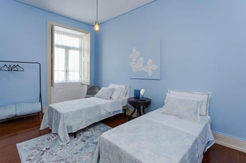a blue room with two beds and a table at 708 Mugnano House Aveleda in Vila do Conde