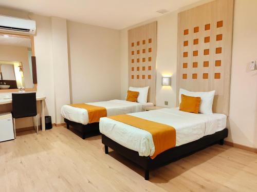 een hotelkamer met 2 bedden en een televisie bij Hotel 98 in Kuching