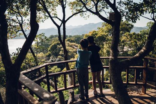 two people standing on a bridge looking at the trees at Villa Yumigahama in Minamiizu