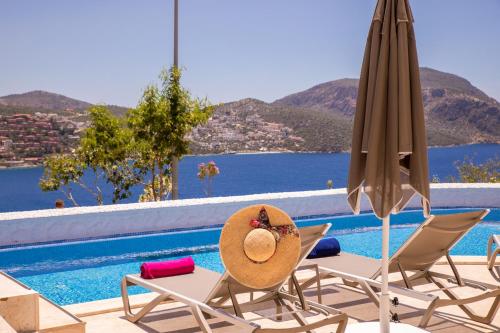 a hat sitting on chairs next to a swimming pool at Kalkan Saray Suites Hotel in Kalkan