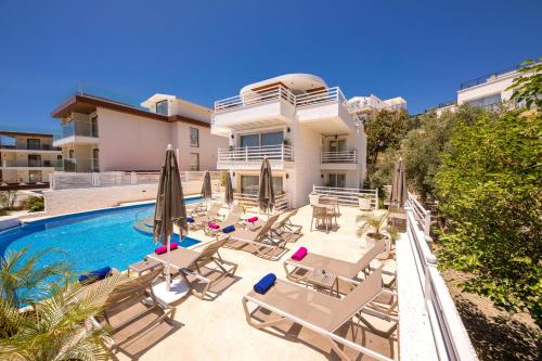 a villa with a swimming pool and lounge chairs at Kalkan Saray Suites Hotel in Kalkan