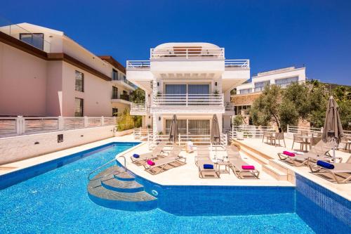 a villa with a swimming pool and lounge chairs at Kalkan Saray Suites Hotel in Kalkan