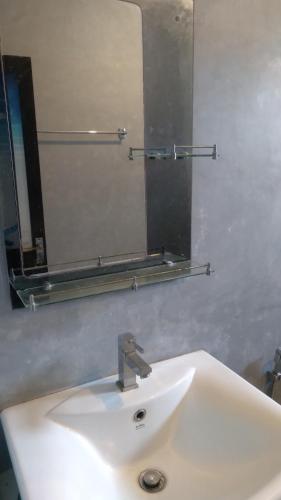 a bathroom sink with a large mirror above it at Osu Lena Habaraduwa in Habaraduwa