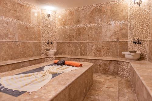 a large bathroom with a tub and two toilets at Kalkan Saray Suites Hotel in Kalkan
