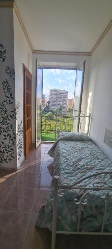 a bedroom with a bed and a large window at I Sollazzi in Palermo
