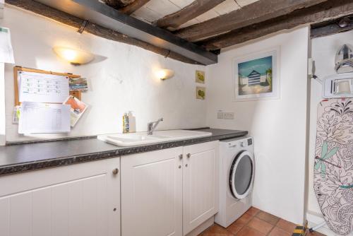 a kitchen with a sink and a washing machine at The Oval in Dunster