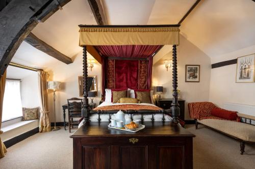 a bedroom with a canopy bed with a wooden table at The Oval in Dunster