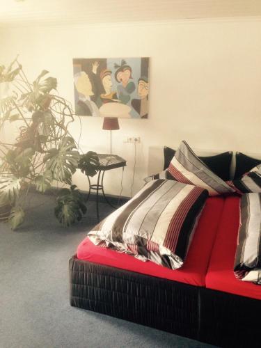 a red couch with a blanket on it in a room at Landhaus Goldenes Kreuz in Leutkirch im Allgäu