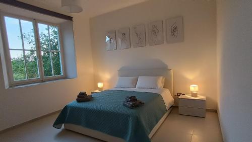 ein Schlafzimmer mit einem Bett mit einer blauen Decke und einem Fenster in der Unterkunft Civico 7 in Bacu Abis
