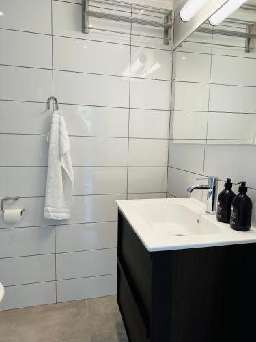 a white bathroom with a sink and a mirror at Studio house with sea view in Stockholm in Tyresö