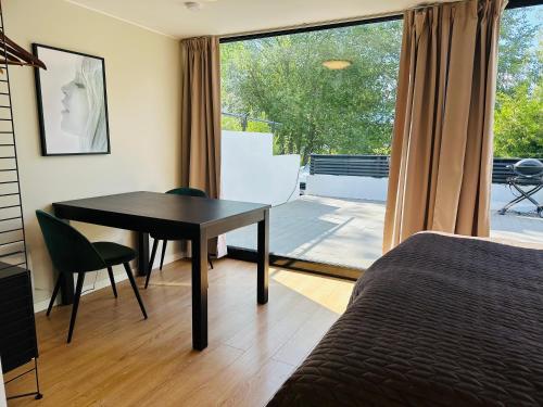 um quarto com uma secretária, uma mesa e uma janela em Studio house with sea view in Stockholm em Tyresö