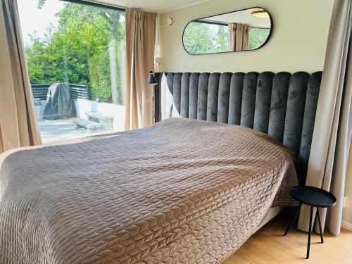 a bedroom with a large bed with a large window at Studio house with sea view in Stockholm in Tyresö
