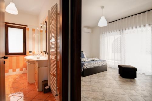 Un baño con una cama y un lavabo en una habitación. en Villa Estia - nel cuore della Valle D'Itria, en Cisternino