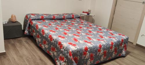 a bedroom with a bed with a flowered blanket at La Mocina casa vacanze in Castellaro