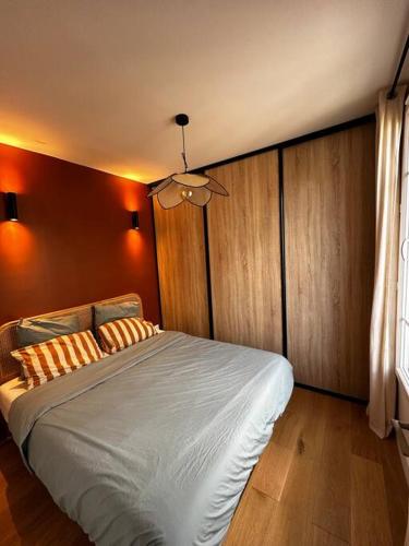 une chambre avec un grand lit blanc avec des murs orange dans l'établissement Appartement charmant - Batignolles/Montmartre, à Paris