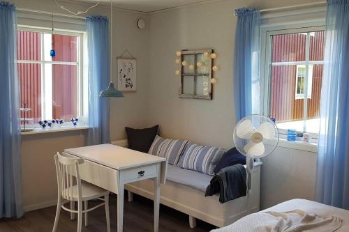 un soggiorno con divano, tavolo e finestre di Cabin located in a traditionally Swedish setting! a Umeå