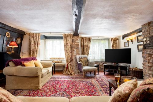 a living room with a couch and a flat screen tv at The Oval in Dunster