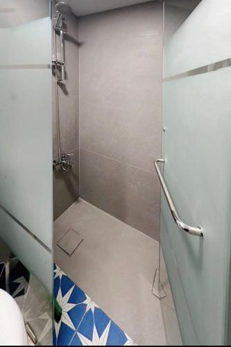 y baño con ducha y puerta de cristal. en Duplex guest house in Batroun, en Batroun