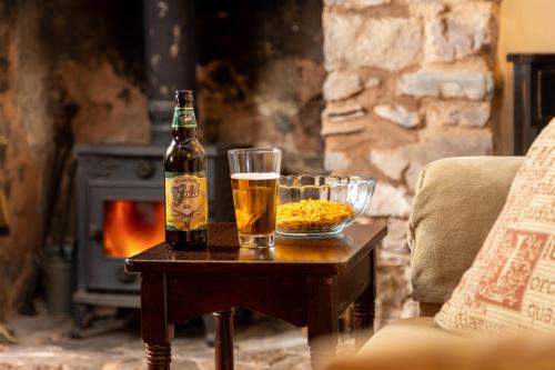 a bottle of beer and two glasses on a table at The Oval in Dunster