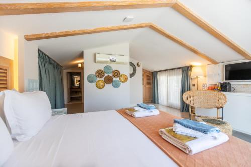 a bedroom with a white bed and a kitchen at Kalkan Saray Suites Hotel in Kalkan