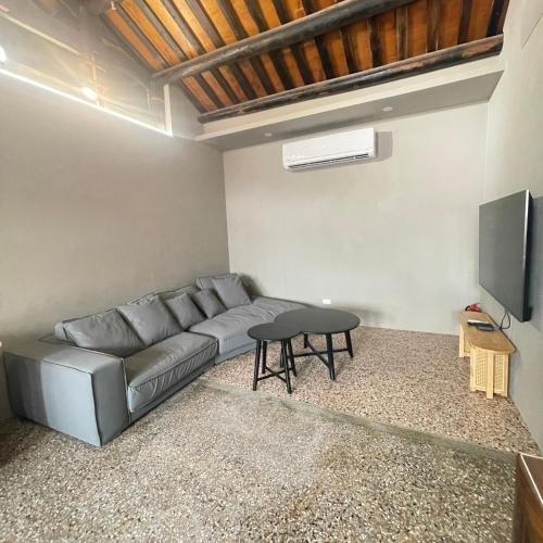 a living room with a couch and a tv at 老宅拾光Lao Shih Kuang-預訂後聯繫才會保留 in Tainan