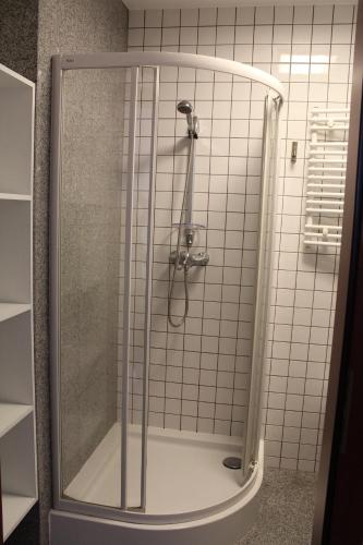 W łazience znajduje się prysznic ze szklanymi drzwiami. w obiekcie Uroczysko Porszewice - Ośrodek Konferencyjno-Rekolekcyjny Archidiecezji Łódzkiej w mieście Pabianice