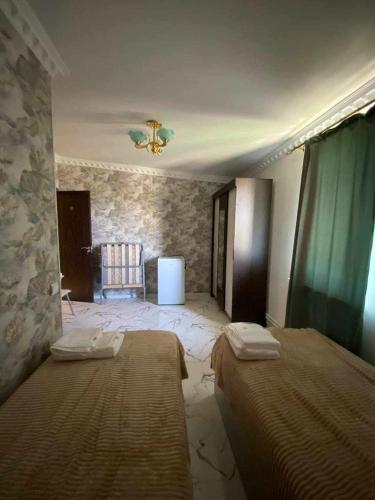 a bedroom with two beds and a stone wall at Hotelvvv888 in Yerevan