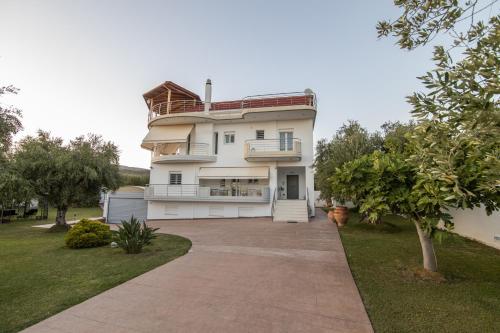 ein großes weißes Haus mit Auffahrt in der Unterkunft Κτήμα Ζιάκος in Mesolongi