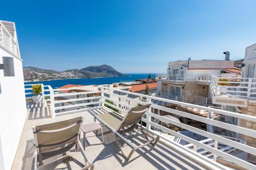 a balcony with chairs and a view of the ocean at Kalkan Saray Suites Hotel in Kalkan