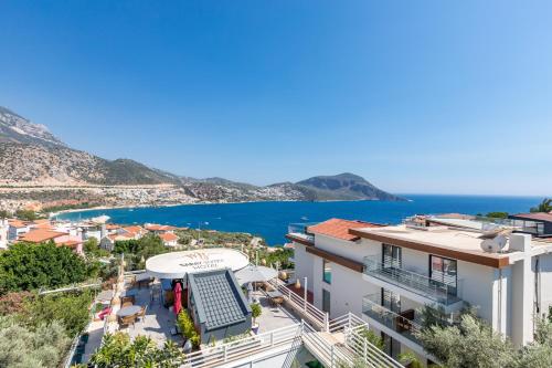 a view of a building with the ocean in the background at Kalkan Saray Suites Hotel in Kalkan
