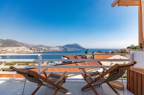 a balcony with a table and chairs and the ocean at Kalkan Saray Suites Hotel in Kalkan