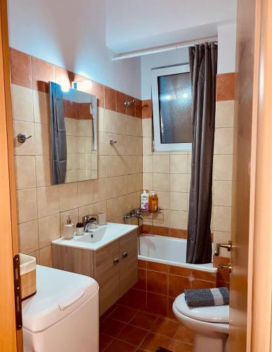 a bathroom with a sink and a toilet and a tub at 22 Apartment with private parking in Larisa