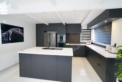 a kitchen with black cabinets and a white counter top at A Dreamed Home Away From Home in Rotorua